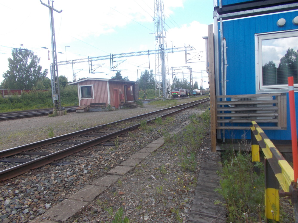 Pellon vaihdekoppi ja T 2728:n lähtövalmistelut 29.6.2017
Lyhyenläntää Kouvolan sekatavarajunaa valmistellaan lähtöön Joensuun ratapihalta. Kaksi tölkkiä, oletettavasti Onttolasta ja yksi tyhjä raakapuuvaunu välissä.
Avainsanat: op_VR;jt_Tavarajuna;jt_Runkojuna;jyv_Sr1;jyv_Soek;jyv_Sp;jyv_Sonk;infra_vaihdekoppi