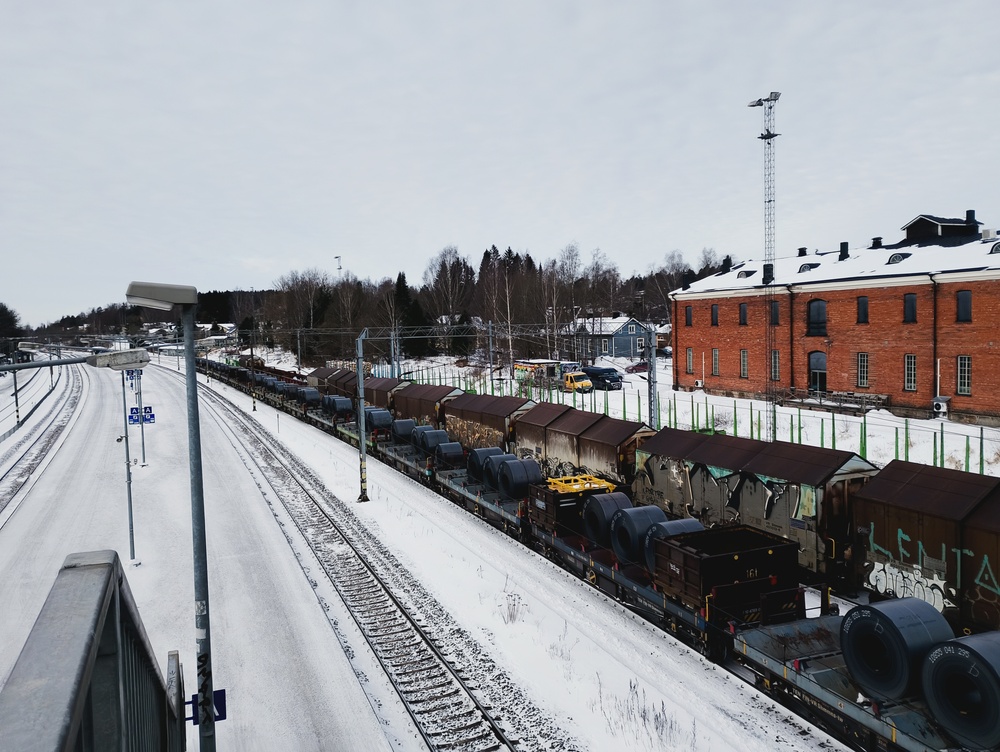 Hämeenlinnan täyttä ratapihaa 25.2.2026
Liikenteen määrään nähden on Hämeenlinnan ratapiha vars in pieni ja täyttä oli nytkin. Lähimmällä raiteella Raahesta saapuneita teräskelavaunuja, joiden takana Tamperetta kohti pyrkivä tavarajuna, jonka keulilla äsken mainitun teräskelajunan veturit ovat juuri hiipineet. Näiden takana yksi yhä tyhjä raide, joka sai hetkeä myöhemmin täytteeksi junan Hangosta ja takimmaisella raiteella onkin kuormauksesa päivystäjän samana aamulla sille tyrkkäämiä raakapuuvaunuja.
Avainsanat: op_VR;jt_Tavarajuna;jt_Asiakasjuna;jt_Runkojuna;jyv_Shmmn-tw;jyv_Shmnns-tw;jyv_Shimmn;jyv_Sps