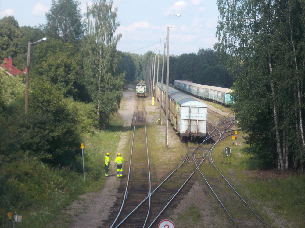 Junia Heinolassa 13.7.2018
Tyhjiä kartonkivaunuja tuonut PAIkku on juuri saapunut Lahdesta. Ratapihalla näkyvä deeveripari odottelee lähtöä veturijunana takaisin Riihimäelle, palattuaan ilman vaunuja Rautsalosta vietyään sinne letkan raakapuuta.
Avainsanat: op_VR;jt_Vaihtotyö_PAI;jt_Veturijuna;jyv_Dv12;jyv_Gbln;jyv_Gbls;jyv_Hbi;juna_heinolalainen