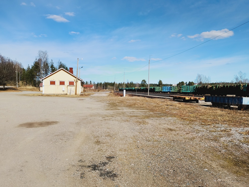 Kevätpäivä Heinolassa 12.4.2026
Puinen tavaramakasiini on säilynyt, joskaan käyttöä ei taida juuri olla. Kehnomman kohtalon kokeneen puisen asemarakennuksen paikalle on sen sijaan pykätty parakkiasema.
Asemn hyljätyn oloisesta ulkomuodosta huolimatta Heinolan tavaraliikenne on hengissä, sillä raakpuuta, puuhaketta ja kartonkia kulkee. Kuvassa näkvissä kuormattavana olleita raakapuuvaunuj.
Avainsanat: op_Fenniarail;jyv_Vop;infra_tavaramakasiini