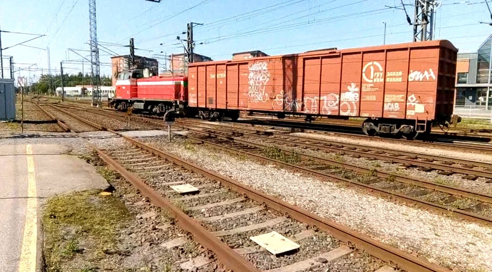 Turun päivystäjän lähtö Raisioon.
Päivystäjän 6181 eli vanhan kunnon Turku ykkösen ominaisuudessa toimiva Dv12 2527 on juuri lähtenyt Turun päärautatieaseman edessä olevilta tavararaiteilta viemään yhden vaunun kuormaa Raisioon. Raision liikenne oli tässä kohtaa koostunut jo useamman vuoden yksittäisistä venäläisistä umpivaunuista ja Venäjän hyökättyä Ukrainaan se on päättynyt kokonaan.
Päivystäjän paluumatka Raisiosta oli vähän monimutkaisesti, sisältäen käynnit Pernon telakalla sekä kantasatamassa, joista molemmista nostettiin vaunuja.
Avainsanat: op_VR;jt_Vaihtotyö;jt_Vaihtotyö_PAI;jyv_Dv12;jyv_Vgk;päivystäjä_Turku