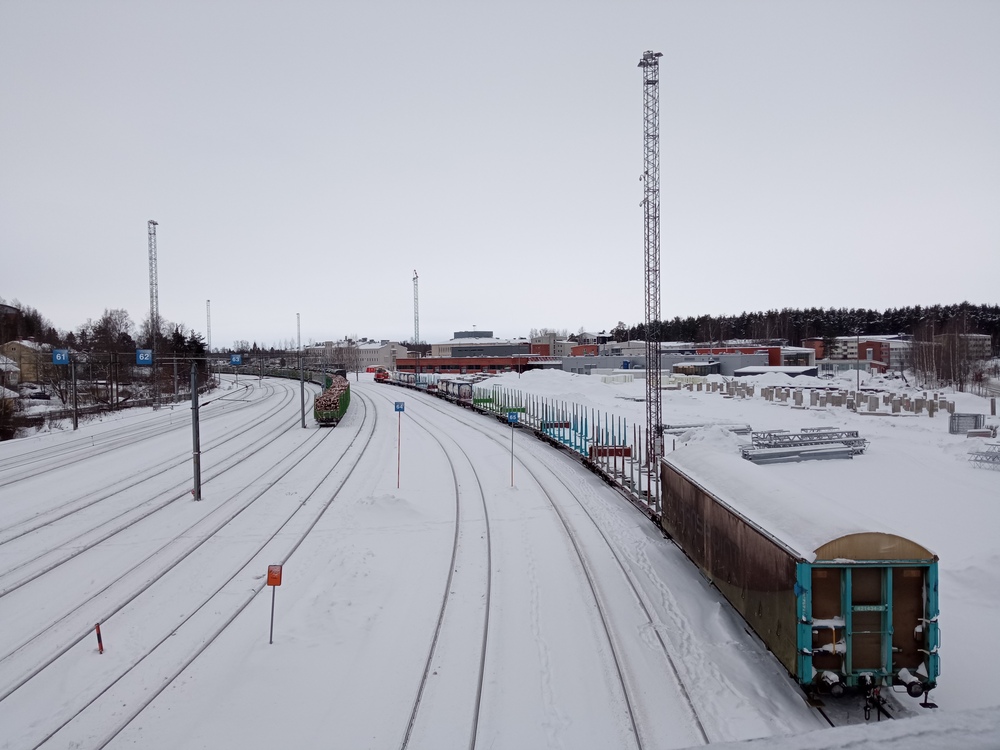 Peltolan ratapiha 4.1.2022
Päivystäjällä on koukussaan sekalainen vaunuletka, ratapihalla seisoo raakapuuletka sekä siilovaunuja (kenties Puhoksesta tulossa?). Peltolan kuormausalue on jäänyt käytöstä ja muuttunut alkamassa olevan Joensuun ratapihatyömaan varastokentäksi.
Avainsanat: op_VR;jt_Vaihtotyö;jyv_Hain;jyv_Sp;jyv_Sps;päivystäjä_Joensuu