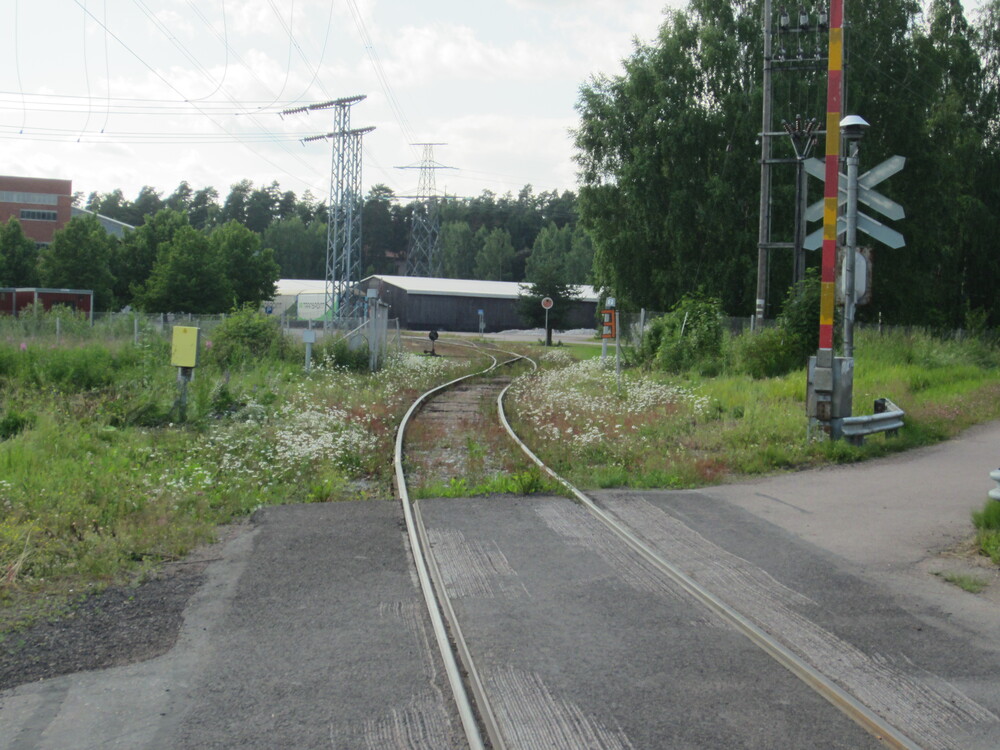 Kartonkitehtaan pohjoinen raide 14.7.2015
Kartonkitehtaan raiteen pojoinen haara Valtatien tasoristeyksestä, taustalla näkyy pressuvaunuja tehtaalla. Tämän raiteen liikenne on sittemmin hiljentynyt.
